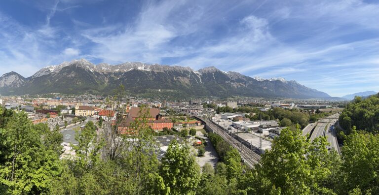 Panoramablick über Innsbruck und die Nordkette bei blauem Himmel.