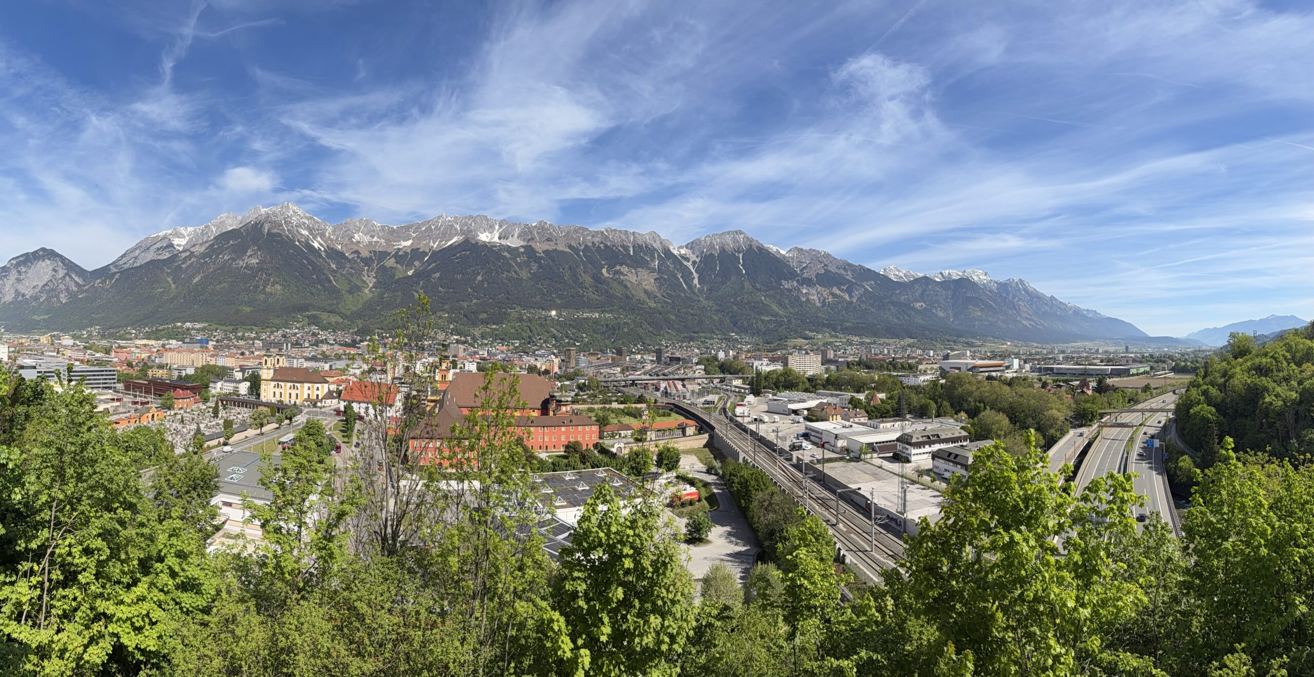 Panoramablick über Innsbruck und die Nordkette bei blauem Himmel.