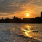 Sonnenuntergang über ruhigem Wasser mit goldenem Lichtspiegel auf der Oberfläche. Das Bild symbolisiert Reflexion, Selbsterkenntnis und den Gedanken des inneren Spiegels.