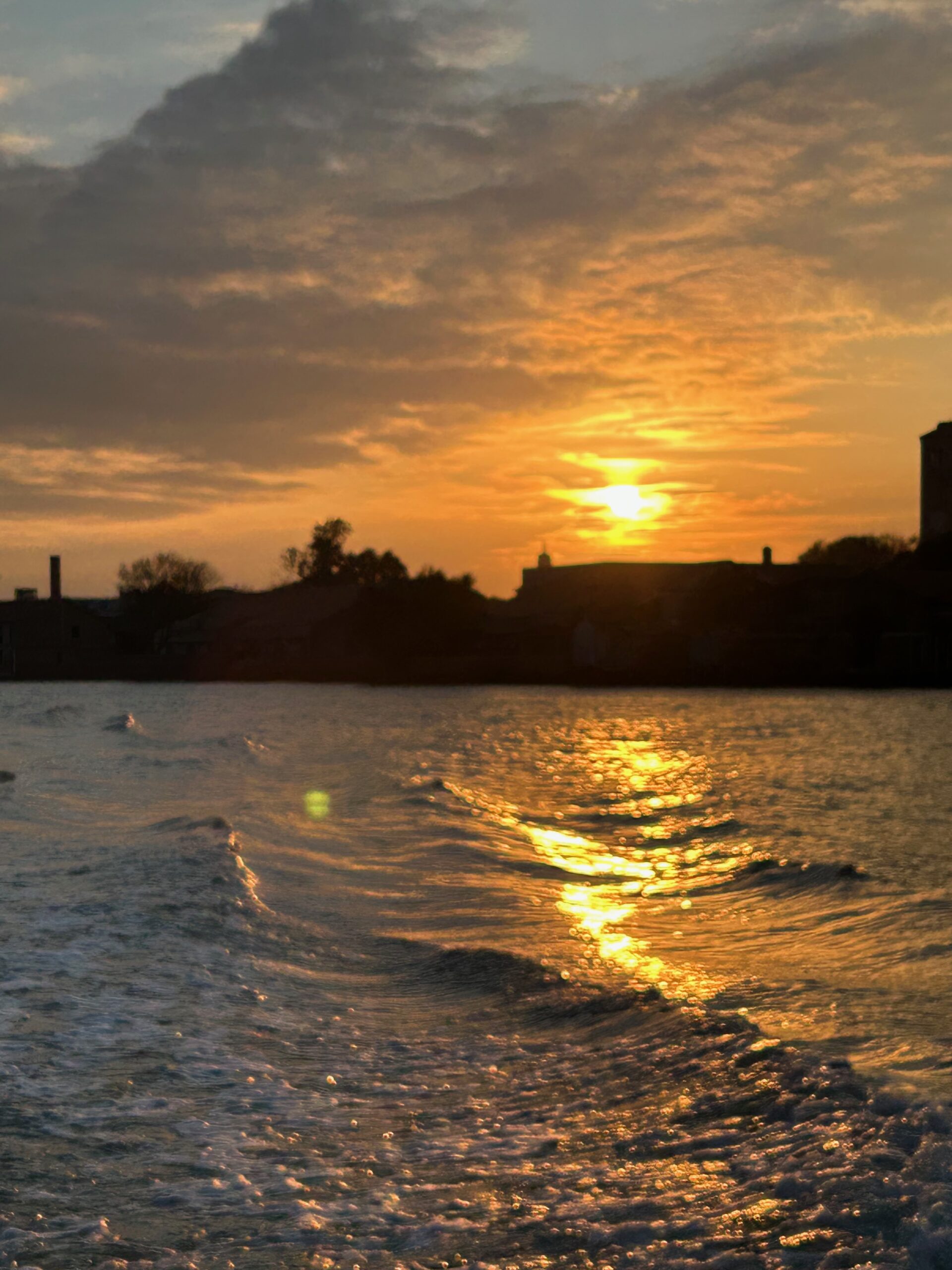 Sonnenuntergang über ruhigem Wasser mit goldenem Lichtspiegel auf der Oberfläche. Das Bild symbolisiert Reflexion, Selbsterkenntnis und den Gedanken des inneren Spiegels.